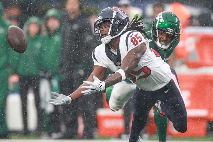 Dec 10, 2023; East Rutherford, New Jersey, USA; Houston Texans wide receiver Noah Brown (85) reaches for a pass during the first half in front of New York Jets cornerback D.J. Reed (4) at MetLife Stadium. Mandatory Credit: Vincent Carchietta-USA TODAY Sports